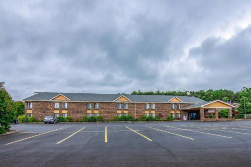 a large brick building with a parking lot at Quality Inn Tully I-81 in Tully