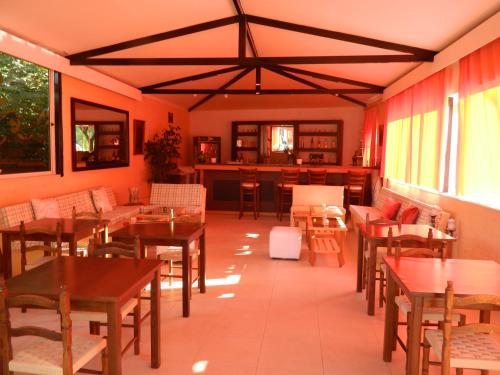 a restaurant with wooden tables and chairs and windows at Asteri Studios in Skiathos Town
