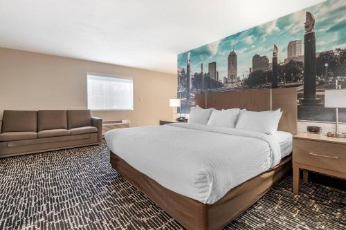 a hotel room with a bed and a couch at Clarion Pointe Indianapolis Airport in Plainfield