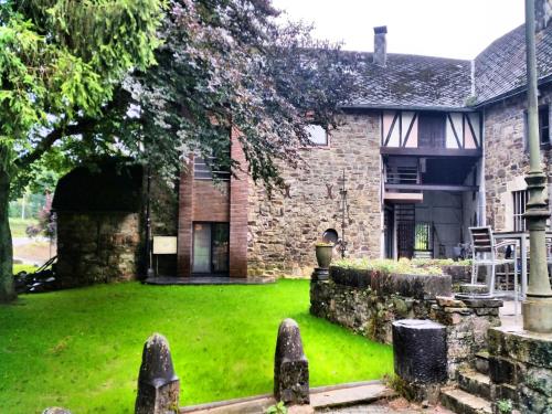 an old stone house with a green yard at Manor house flat in Robertville in Robertville