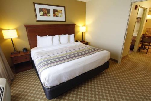 a large bed in a hotel room with two lamps at Country Inn & Suites by Radisson, Crystal Lake, IL in Crystal Lake