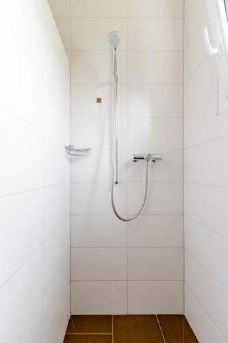 a bathroom with a shower with white tiles at Montaney Guests House - EPFL in Ecublens