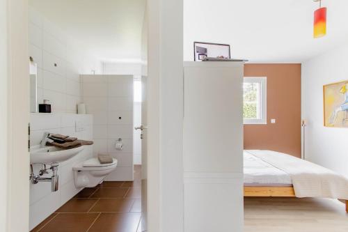 a bathroom with a bed and a toilet and a sink at Montaney Guests House - EPFL in Ecublens