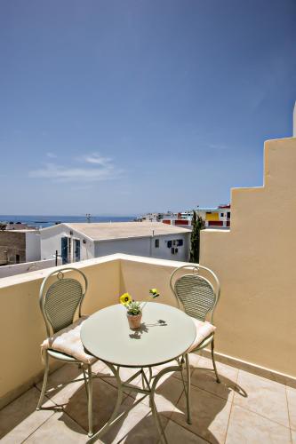 a small table and chairs on a balcony with a view at Tiniotissa Studios in Tinos