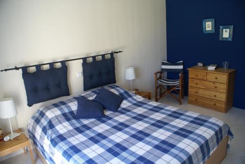 a bedroom with a blue and white bed and a dresser at O Ioannis in Kritinía