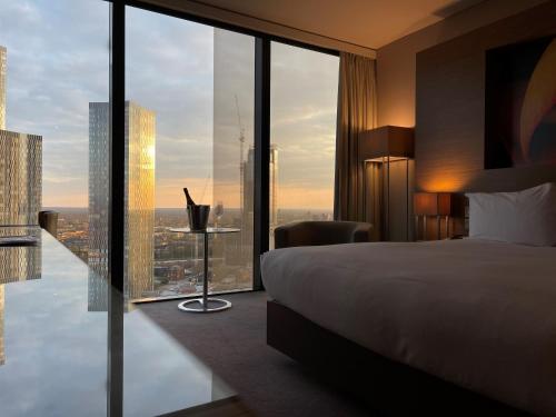 a hotel room with a bed and a large window at The Manchester Deansgate Hotel, by IHG in Manchester