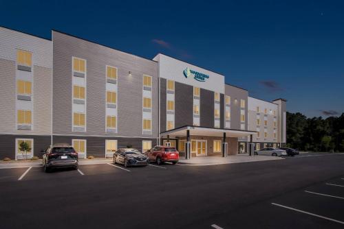 a large building with cars parked in a parking lot at WoodSpring Suites Sumter near Shaw AFB in Sumter