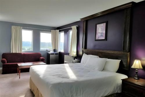 a bedroom with a large bed and a red chair at Ramada by Wyndham Florenceville in Florenceville
