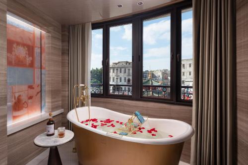Un baño con bañera y ventana. en 汕头Diotel皇后酒店, en Shantou