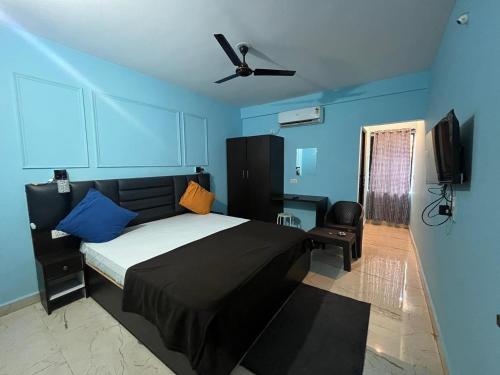a bedroom with a bed and a ceiling fan at The Boss House in Arambol