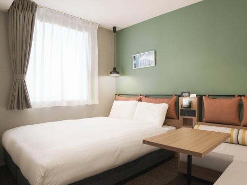 a hotel room with a bed and a table at Comfort Hotel Mito in Mito