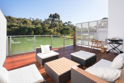 a balcony with furniture and a view of the water at Ohana A - WIFI, 10 minutes to the cafe strip in Margaret River Town