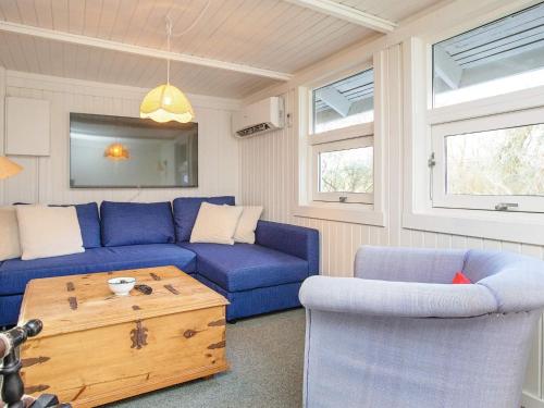 a living room with a blue couch and a coffee table at 4 person holiday home in Præstø in Præstø