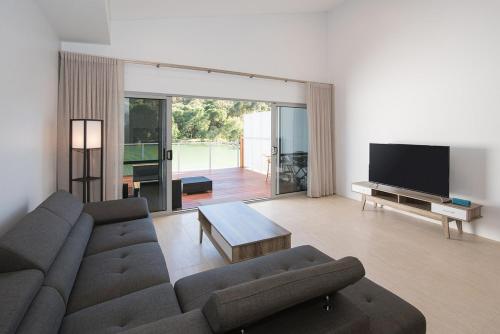 a living room with a couch and a tv at Ohana A - WIFI, 10 minutes to the cafe strip in Margaret River Town