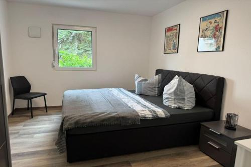 a bedroom with a bed and a chair and a window at Living-Apartment-mit-Kamin-und-Terrasse in Dresden