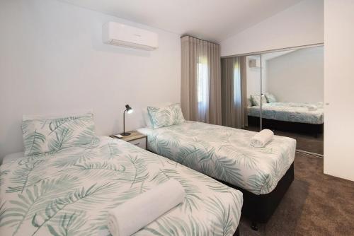 a hotel room with two beds and a mirror at Ohana A - WIFI, 10 minutes to the cafe strip in Margaret River Town