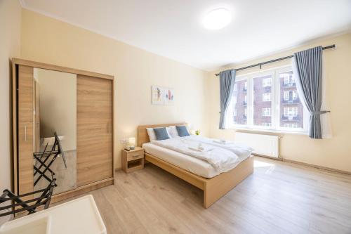 a bedroom with a bed and a large window at Central 4BEDROOM Madách Square Apartment in Budapest