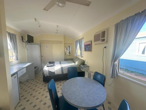 a room with a bed and a table and chairs at The Eulo Queen Hotel 