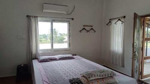 a bedroom with a bed and a window at Beverly Dinesh Homestay in Tiruvannāmalai