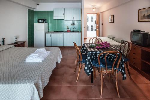 cocina y comedor con mesa y sillas en Eolcalandra Case Per Vacanza, en Canneto
