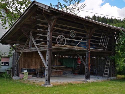 a wooden pavilion with a ladder in a yard at Holiday home Anna Comfortable Vacation Home in Faak am See