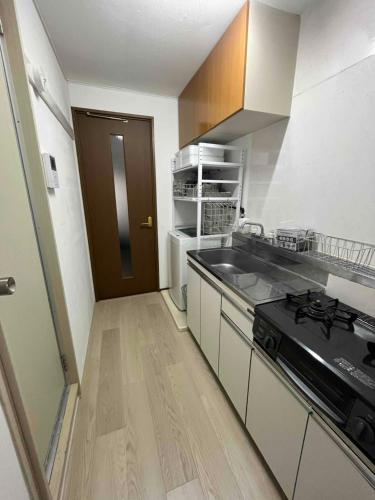 a kitchen with a sink and a stove in it at KT2 ブロッサムガーデン103号室Blossom Garden103 in Takahate