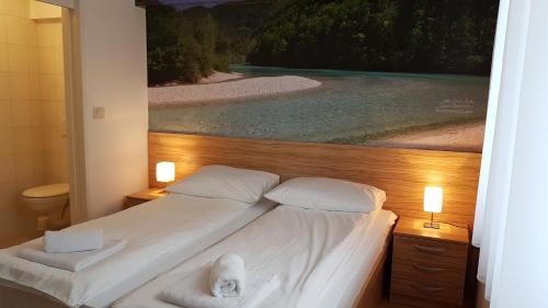 a bedroom with a bed with a painting on the wall at B&B By The Way in Ljubljana