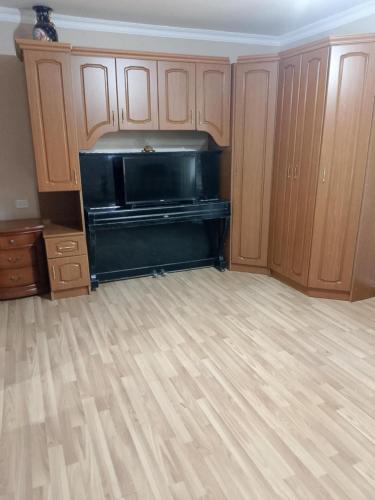 Una cocina con un piano negro en una habitación. en Anush, en Sisian