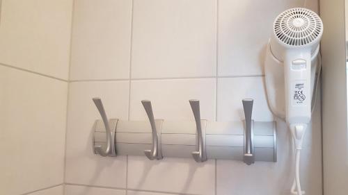 a bathroom wall with a hair dryer and five knives at B&B By The Way in Ljubljana