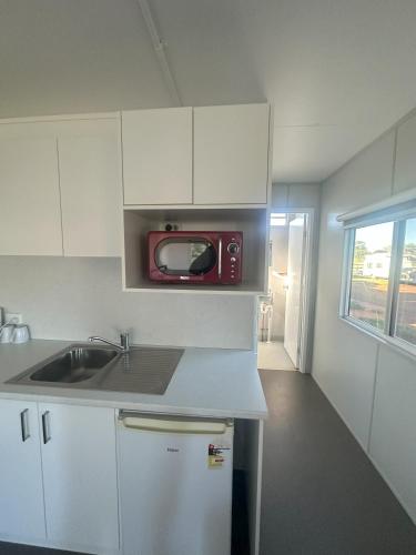 a kitchen with a sink and a microwave at The Eulo Queen Hotel 