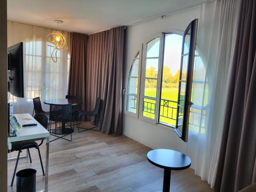 a living room with a table and two windows at Adagio Serris Val d'Europe in Serris
