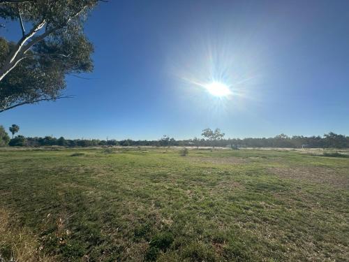 a field with the sun in the sky at The Eulo Queen Hotel 