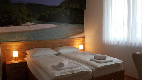 a bedroom with a bed with two towels on it at B&B By The Way in Ljubljana