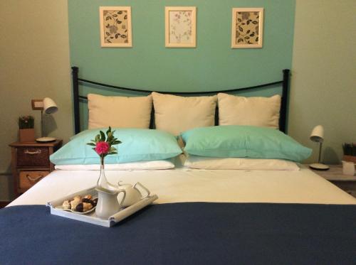 a bed with a vase with a flower in it at Sweet Home & Apartments in Fontane Bianche