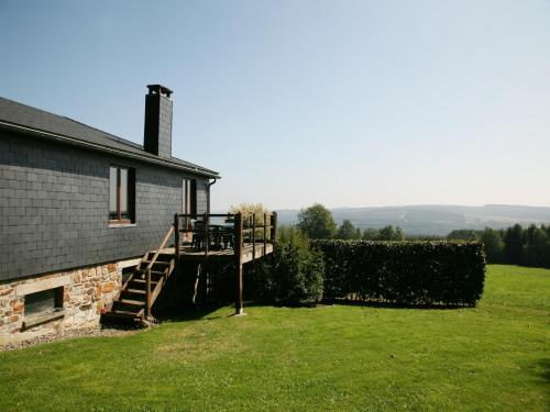 a house with a wooden staircase next to a yard at Cozy Cottage, Basse-Bodeux in Trois-Ponts