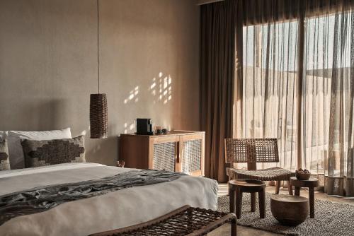 a bedroom with a bed and a chair and a window at Casa Cook El Gouna - Adults Only in Hurghada
