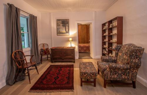 a living room with two chairs and a table at Cozy Cottage Blue Mountains in Lowther