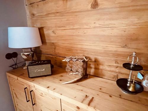 a wooden wall with a lamp and glasses on a dresser at SEPPKEUSCHE - historisches Chalet mit Zirbensauna und Hotpot in Turracher Hohe