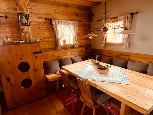 a dining room with a wooden table and chairs at SEPPKEUSCHE - historisches Chalet mit Zirbensauna und Hotpot in Turracher Hohe