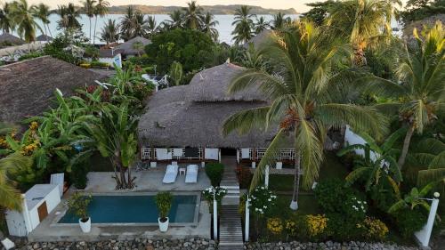 an aerial view of a house with a thatch roof at Villa SAHONDRA in Nosy Be