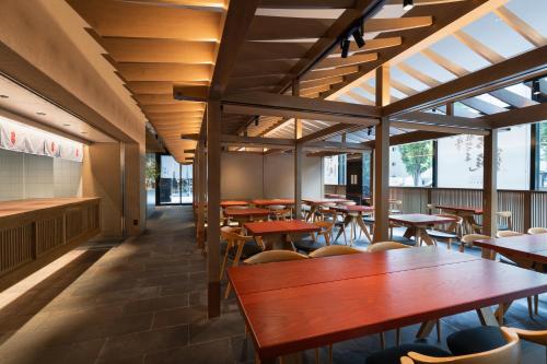 an empty restaurant with wooden tables and chairs at Mitsui Garden Hotel Fukuoka Gion in Fukuoka