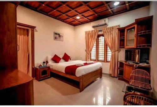 a bedroom with a bed and a television in it at AVERA Heritage Homestay in Thekkady