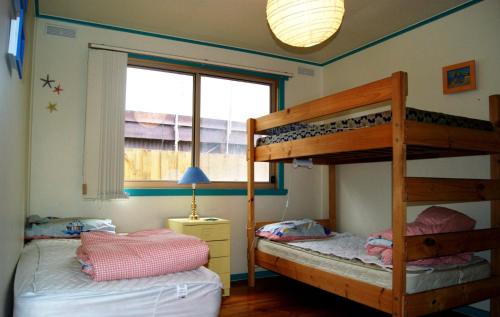 a bedroom with two bunk beds and a window at Inlet Side Eden in Inverloch