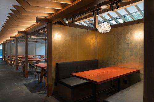 a row of tables and benches in a restaurant at Mitsui Garden Hotel Fukuoka Gion in Fukuoka
