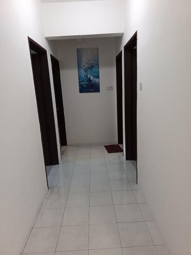 a hallway with black doors and a white tile floor at Lumut Valley in Lumut