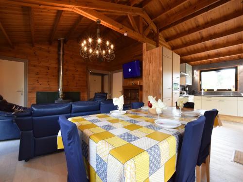 a dining room with a table and blue chairs at Renovated chalet near Durbuy in Durbuy