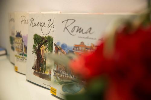 a row of books on a shelf with a picture of rome at Le Petit Boutique Hotel in Santander