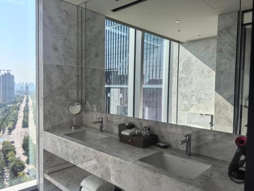 a bathroom with two sinks and a large mirror at Hyatt Regency Xi'An Chanba in Xi'an