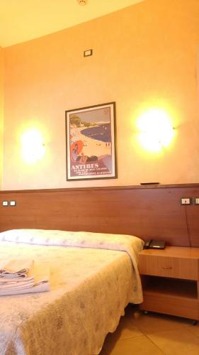 トリノにあるAffittacamere Parellaのベッドルーム1室(ベッド1台付)が備わります。壁に絵が飾られています。