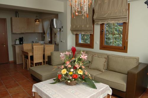 a living room with a table with a vase of flowers on it at Safetis Stories in Díon
